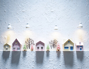 Cute Paper Craft Houses with Trees in Winter on White Wall under Spotlight, Generative AI