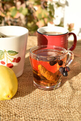 Two cups of tea with lemon and berries on a linen tablecloth