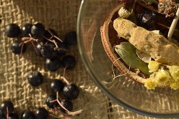 Herbs and spices  and turmeric root in a glass bowl on a burlap background