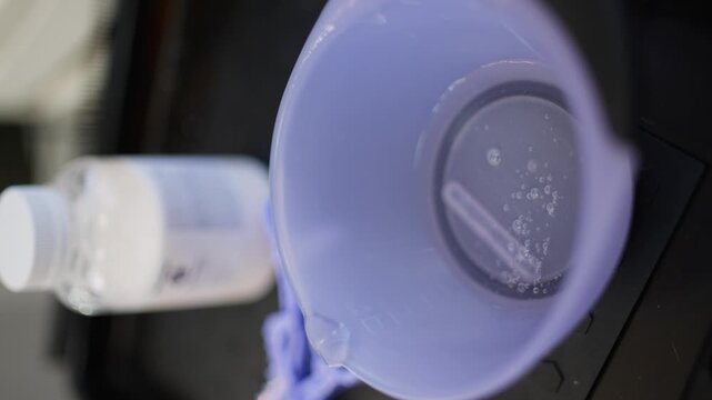 A close-up of a hairdressing bowl with a mask being applied with a brush. High quality 4k footage