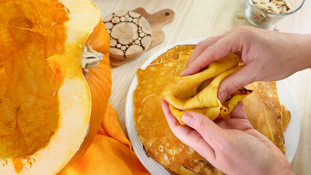 Feast your senses on pumpkin crepes being artfully folded, evoking harvest festival warmth and Samhains rustic charm