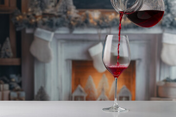 Pouring red wine into the glass. Christmas background