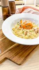 Creamy risotto crowned with vibrant salmon ribbons, evoking the cozy embrace of Hygge and the indulgence of Slow Food