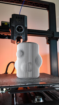 Futuristic 3D printer sculpting wavy vase, echoing Moebius strip mysteries, ideal for World Creativity Day, tech innovation