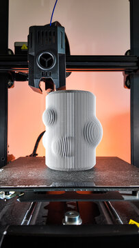 A futuristic 3D printer sculpts a wavy vase, embodying modern craftsmanship and Miro-inspired digital creativity during Innovation Day