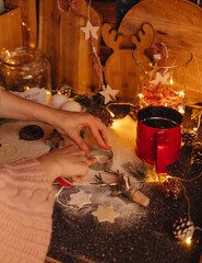 the hand of a woman baking Christmas cookies