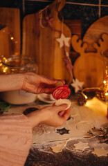 the hand of a woman baking Christmas cookies