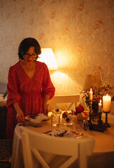A woman is setting the table for Christmas dinner