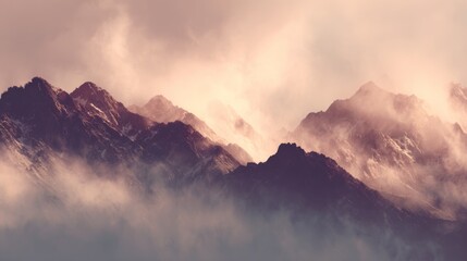 Obraz premium Majestic mountain landscape shrouded in mist and clouds during sunrise, showcasing rugged peaks and enchanting natural beauty in soft pastel colors