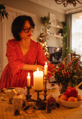 A woman is setting the table for Christmas dinner