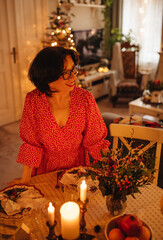 A woman is setting the table for Christmas dinner