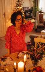 A woman is setting the table for Christmas dinner