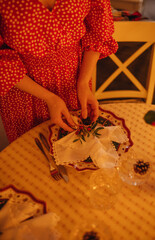 the hand of a woman setting the table for Christmas dinner