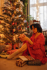 a woman with gifts under the Christmas tree