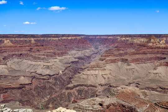 Vast canyon view with deep erosion layers and vivid rock textures under clear blue sky