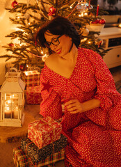 a woman with gifts under the Christmas tree