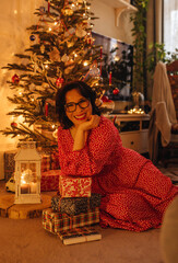 a woman with gifts under the Christmas tree