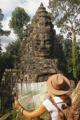 Traveler With Map At Bayon Face Tower, Angkor Thom, Cambodia Tourism