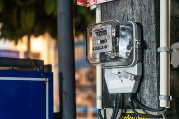 Electrical Meter on a Wooden Post at Night