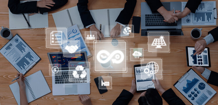 A dynamic business meeting showcases professionals collaborating over sustainability and technology trends while engaging with digital devices, fostering innovation. Trope