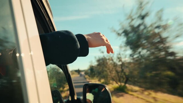 Hand outside car window during road trip , van life good vibes. travel and inspirational content