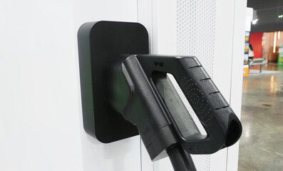 An electric vehicle or EV charging connector docked into a charging station