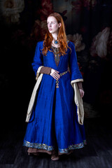 Medieval or high fantasy woman wearing a blue silk dress with hanging gold sleeves
