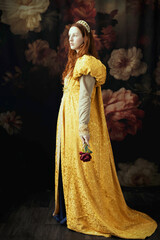 A red-haired woman wearing a historically styled gold gown with puffy sleeves