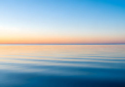 A serene ocean at sunset, showcasing a gradient of colors in the sky - Powered by Adobe