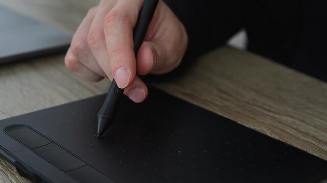 A man working with digital materials.
Using a graphic tablet and stylus.
A man in a fois draws on a graphics tablet.
Photo editing and office work
