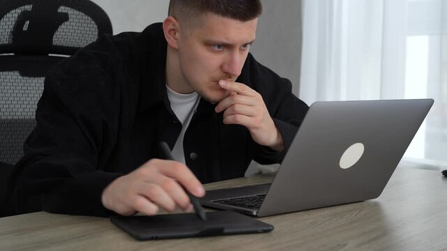 A man working with digital materials.
Using a graphic tablet and stylus.
A man in a fois draws on a graphics tablet.
Photo editing and office work