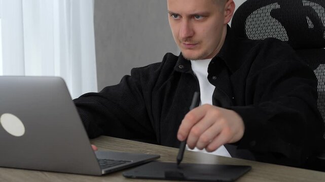 A man working with digital materials.
Using a graphic tablet and stylus.
A man in a fois draws on a graphics tablet.
Photo editing and office work