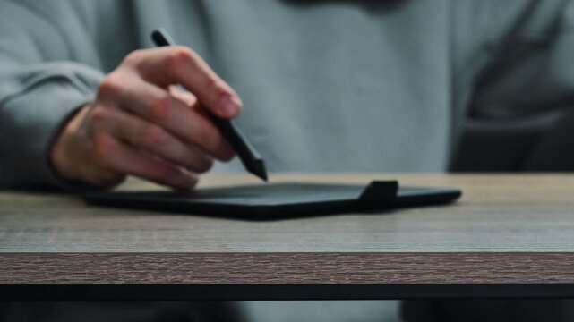 A man's hand with a stylus draws on a graphics tablet.
Digital work.
A graphic designer is developing a logo for a brand.
Work, design, graphics, drawing, digital, technology