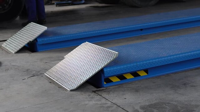 Hydraulic lift in a car service center. Testing a 30,000 kg lifting capacity lift. This lift is ideal for car service centers, professional tool repair shops, and mechanical workshops.