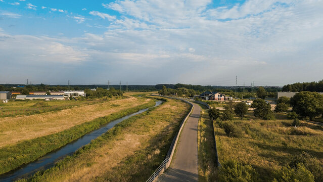 Cyclists riding along riverside road in summer