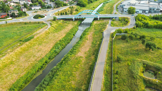 Green cycle route by the flowing river - Powered by Adobe