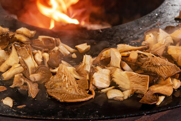 Sliced mushrooms Cardoncelli grilled on a circular barbecue with open fire