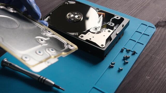 repairman fixing computer hard disk drive in service center