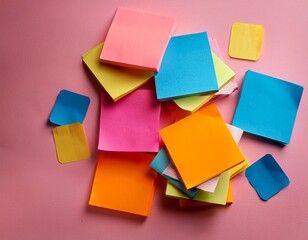 sticky notes of various colors stacked and scattered on a pink surface