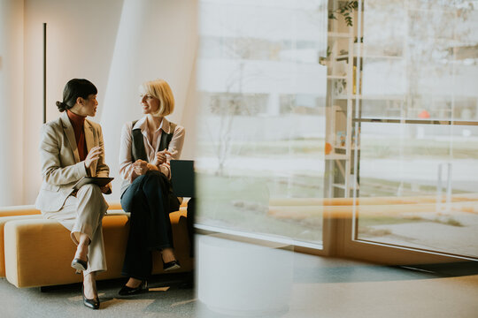 Business professionals engage in conversation in a modern office setting during daytime