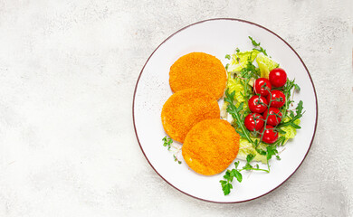 crispy fried fish cutlets, fish burgers, on a white plate, with fresh lettuce leaves, arugula and cherry tomatoes, homemade, no people,