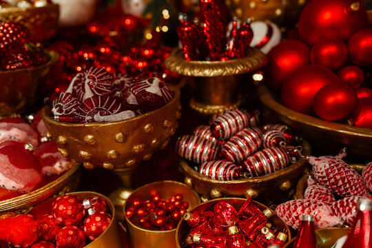 Luxurious Christmas ornaments in rich reds and golds, artfully arranged in vintage bowls. Festive, warm, and opulent — perfect for holiday marketing or seasonal decor inspiration.