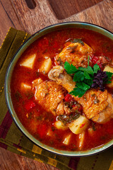 Souzi soup. Georgian dish, meat with oats, tomato sauce and herbs, on a wooden table