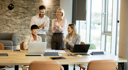 Team celebrating success in a modern office setting during a business meeting