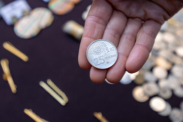 Hand holding 25 pesetas coin at el rastro market
