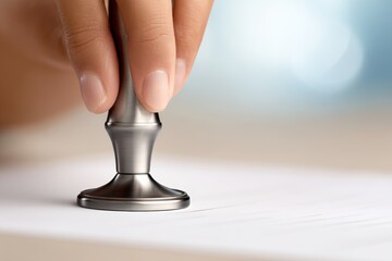 Close-up of hand stamping document with metal stamp