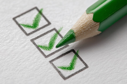 A green pencil is on top of a check box with a green check mark