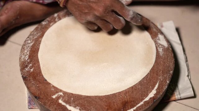 close up of a indian woman making Indian roti or chapati at home. Traditional flatbread preparation by a women.