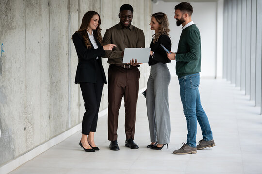 Diverse business people discussing during office hallway meeting - Powered by Adobe