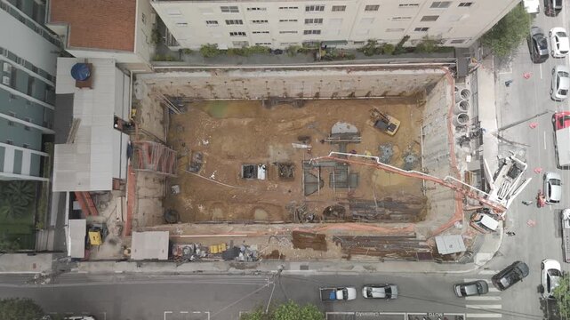 Dramatic Aerial Dolly-Down into Deep Foundation Excavation at Construction Site
